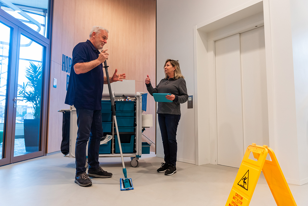 Leidinggevende instrueert schoonmaker