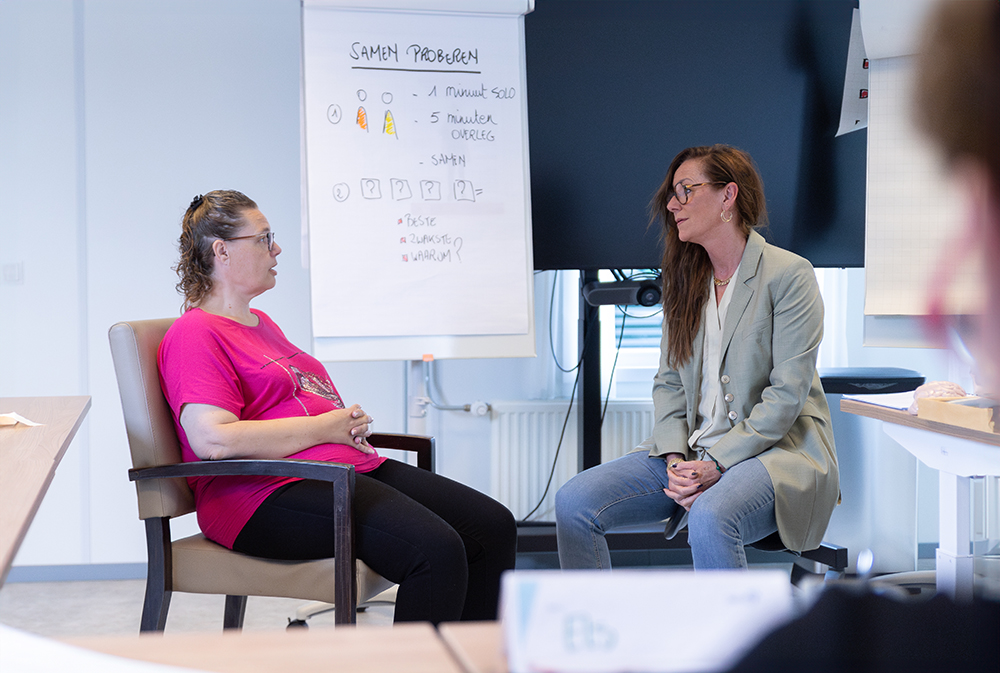 Ann Caroline praat met medewerker tijdens training