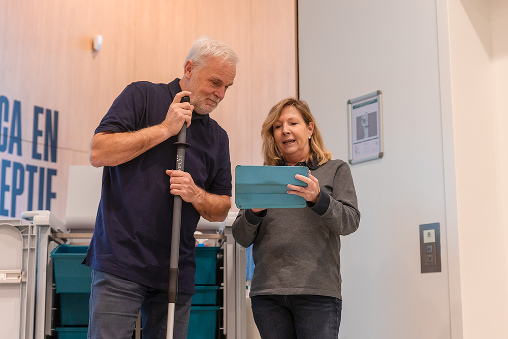 Leidinggevende neemt schoonmaker mee door Leviy op een iPad