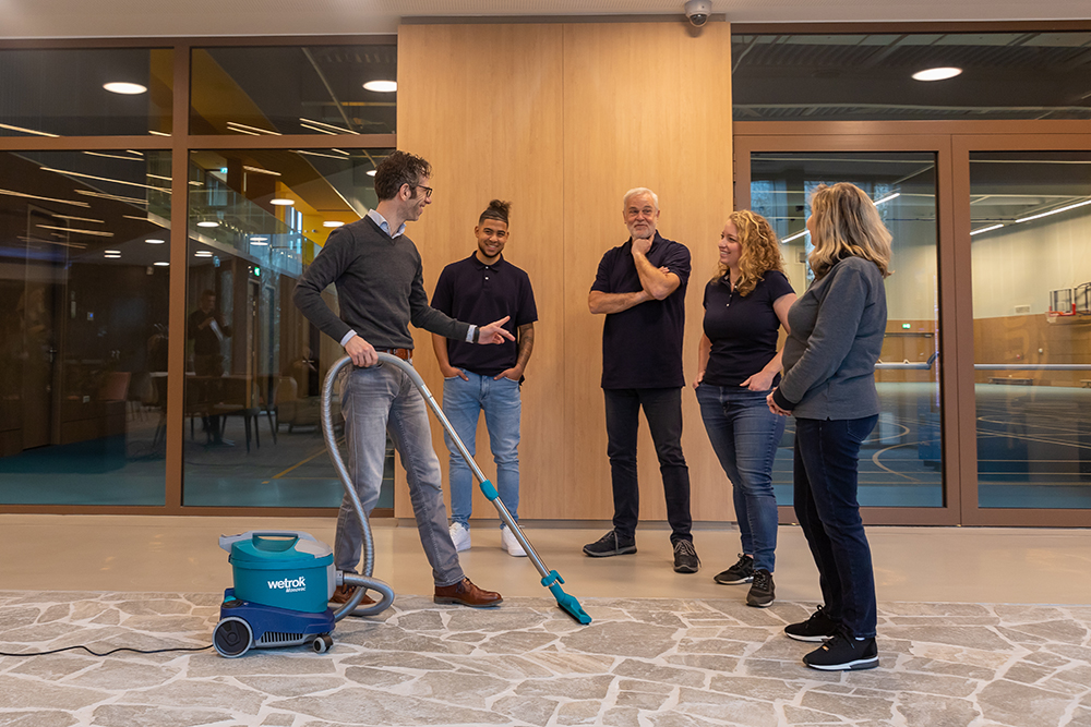 Consultant van Vebego Bright Solutions geeft instructies aan een schoonmaakteam voor het optimaal gebruiken van een stofzuiger