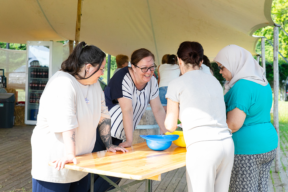 Blije medewerkers doen opdracht met gekleurde bakken tijdens training