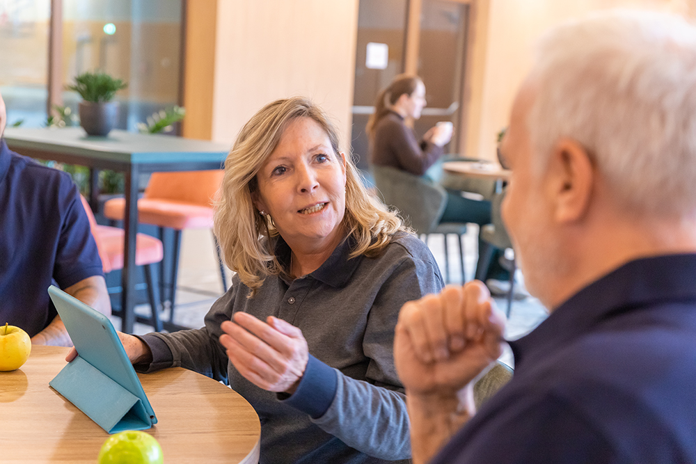 Leidinggevende praat met schoonmaakmedewerker