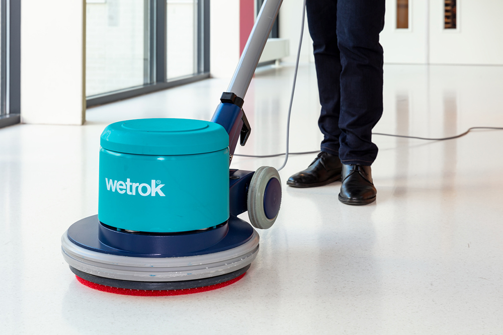 Schoonmaker met eenschijfsmachines maakt vloer schoon