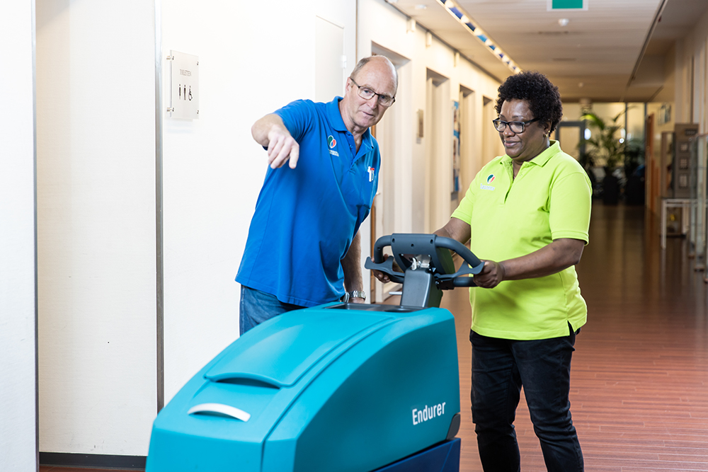 Teamleider en schoonmaker doen vloeronderhoud met Wetrok Endurer